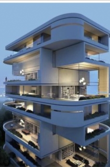 Modern multi- tiered blue concrete building with illuminated glass interiors at night.